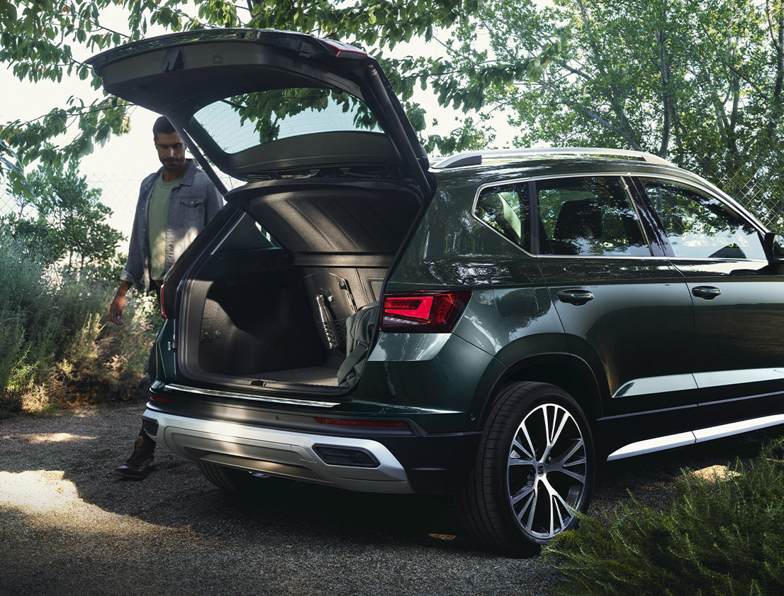 mujer-de-pie-junto-al-seat-ateca-con-protector-del-parachoques-trasero