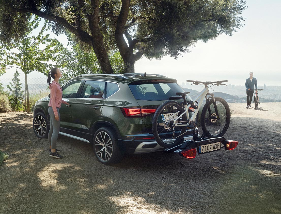 mujer-de-pie-junto-al-seat-ateca-con-un-accesorio-del-portabicicletas