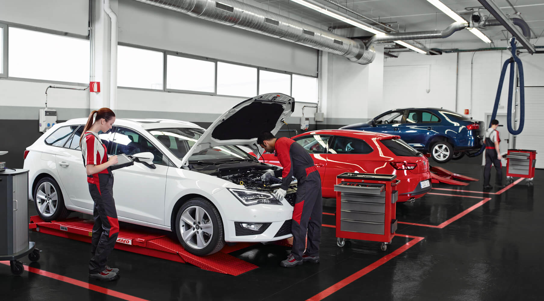 Mantenimiento y servicio de tu coche – Mecánicos de SEAT revisando un coche en un taller